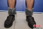 该男子的左右两个脚踝处各用透明胶带绑有1包SD卡 朱标 摄 - 广西新闻网