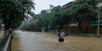 8月14日，受流域内持续强降雨影响，广西柳州市融水苗族自治县融江河水暴涨，县城老城区被淹，居民只得乘船出行。这是融水县今夏第二次遭遇洪水袭击，距离上次被淹仅过了一个半月。据融水县防汛办信息，8月14日16时，融水水文站水位为111.65米（警戒水位10d6.6米）。目前，水位仍在上涨，柳州市已经启动防洪Ⅳ级应急响应。图为民众冒雨在洪水中跋涉。蒙鸣明 摄 - 广西新闻