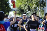 热心市民手举国旗为跑者们加油呐喊。中新网记者 李霈韵 摄 - 广西新闻网