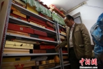 陈俊展示收藏奇石的柜子。　朱柳融 摄 - 广西新闻