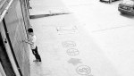 摩托车店门口的监控画面：14时32分，年轻人从地上捡起一个细长物体，用它摆弄门锁。 - 广西新闻网