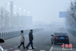 12月20日傍晚时分，华灯初上的新疆乌鲁木齐市依旧被雾霾天气所笼罩，外出民众脚步匆匆。据环保部网站全国城市空气质量小时报数据显示：当日18时，乌鲁木齐市AQI指数为266，首要污染物为PM2.5，空气质量级别为重度污染。 中新社记者 刘新 摄 - 广西新闻网