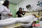 图为音乐治疗师在病房为烧伤患者演奏。　张畅 摄 - 广西新闻网