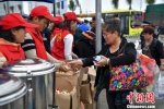 图为在海口新海港志愿服务点，志愿者向滞留旅客免费发放食品。　骆云飞 摄 - 广西新闻网