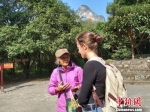 11月27日，广西阳朔月亮山景区，“月亮妈妈”徐秀珍与外国游客用英语交谈。　欧惠兰 摄 - 广西新闻